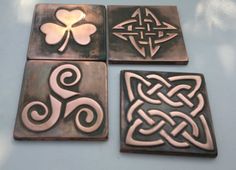 four metal coasters with celtic designs on them