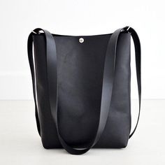 This convertible backpack, the Crossback 3-in-1 Bag, is as beautiful as it is practical! Convert from shoulder or crossbody to a backpack with this one bag!Black LeatherBlack Leather Straps...• Fast & FREE USPS Shipping• Made with a single piece of Full-Grain leather• Top extender• Open interior pocket• Shiny nickel hardware• Measurements: 14" wide across top, 11” wide across bottom, 15" high, 5" deep• Handle drop length is 18” - longer strap available upon request• Includes key-clip• Handmade i Minimalist Leather Backpack With Adjustable Strap For On-the-go, Minimalist Leather Backpack With Adjustable Strap, Minimalist Bucket Bag With Detachable Strap For Everyday, Minimalist Leather Backpack With Adjustable Strap For Everyday Use, Minimalist Everyday Bucket Bag With Detachable Strap, Minimalist Bucket Bag With Adjustable Strap For Travel, Minimalist Crossbody Bucket Bag For Travel, Modern Leather Crossbody Backpack For Everyday, Minimalist Travel Bucket Bag With Adjustable Strap