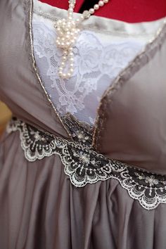 the back of a woman's dress with lace and pearls