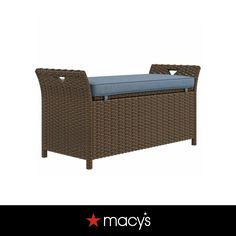 a brown wicker bench with blue cushion on it's back and the words macy's above it