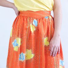 Amazing vintage 80's orange floral satin skirt with blue and yellow flowers print, dotted and pinstripe. This high waist circle skirt has retro style, it's 80's summer midi full skirt, it has yoke and side buttons and zip closure. The skirt is polyester fabric but only retains the old size label, is a used skirt and is not perfect for its age and delicate fabric, has some small loose threads and a small stain, but as its print is so striking is not much appreciated. The modern size is Small, the Retro Pleated Spring Skirt, Retro Pleated Skirt For Summer, Summer Orange Maxi Skirt With Elastic Waistband, Spring Retro Lined Skirt, Retro Flowy Skirt For Spring, Retro Flared Skirt For Spring, Flowy Orange Maxi Skirt With Elastic Waistband, Vintage High-waist Skirt For Spring, Orange Floral Print Long Skirt