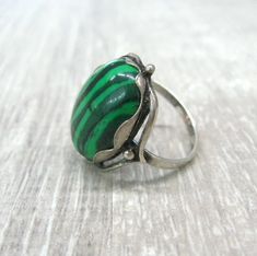 Vintage fashion jewelry, Malachite imitation woman's ring in size 9. Only 1 item available, not adjustable and not resizeable. Very good condition. Size: 9 ( US and Canada ), R 3/4 ( UK and Australia ), 19 ( Europe ). Stone: stripy green MAlachite imitation ( AKA pressed stone or reconstituted malachite ) The stone is oval shape, measuring 14X10 mm and standing 7 mm tall over the finger surface. Material: Silver plated brass. This is a high quality ring in electric silver plate with 980 silver t Elegant Green Malachite Rings, Green Emerald Cabochon Rings, Adjustable Green Malachite Jewelry, Green Turquoise Cabochon Ring, Vintage Green Emerald Open Ring, Vintage Style Open Emerald Ring For Gift, Green Open Ring Jewelry For May Birthstone, Vintage Emerald Green Open Ring, Handmade Retro Green Jewelry