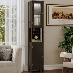 a living room with a white chair and a tall cabinet