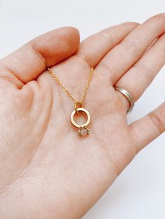 This very elegant engagement ring necklace is perfect for that special occasion. Simple and understated.  It looks great on its own or layered with other necklaces, and is the perfect everyday accessory. Item Details: Pendant: H: 10 mm L: 11 mm W: 1 mm Necklace clasp: lobster clasp. Materials: Pendant: 24k gold plated Chain: 14k gold plated, 17.5 inches or 19 inches Care Instructions: My jewelry carries powerful and positive vibrations.  Give it the care it deserves by avoiding contact with clea Minimalist Wedding Necklace With Ethical Gemstones, Minimalist Gold Necklace For Anniversary, Minimalist Solitaire Necklace For Anniversary, Minimalist Birthstone Necklace With Ethical Diamonds, Minimalist Delicate Chain Jewelry For Anniversary, Minimalist Rose Gold Birthstone Necklace, Rose Gold Solitaire Necklace For Wedding, Minimalist Solitaire Necklace Gift, Minimalist Rose Gold Round Pendant Birthstone Necklace