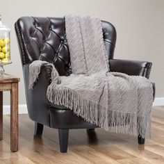 a chair with a blanket on top of it next to a table and lemons