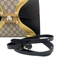 The Gucci Osiride Monogram Top Handle Bag is luxury personified with a black and gold color palette. Designed with royalty and luxury in mind combined with mixed elements this unique handbag will turn many a head. Crafted in the iconic GG supreme canvas with bold calfskin leather details and features antique gold-tone hardware, lined interior with a slip pocket and zipper pocket, two adjustable shoulder straps, front flap with push lock closure and iconic tiger head detail on front closure. This beautiful Gucci Osiride Monogram Top Handle Bag won't last long. Model: 497996 Material: Leather and Supreme Canvas Color: Black and Gold Antique Gold-Tone Hardware Front Flap Front closure with iconic tiger head Microfiber suede lined interior Interior slip pocket and one interior zipper pocket To Luxury Clutch Shoulder Bag, Luxury Clutch Shoulder Bag Fashion Accessory, Luxury Gold Bags With Branded Hardware, Black Bags With Palladium Hardware, Designer Gold Shoulder Bag With Detachable Handle, High-end Gold Shoulder Bag For Everyday, Luxury Gold Shoulder Bag With Detachable Handle, Luxury Gold Bag With Palladium Hardware, Luxury Shoulder Bag With Detachable Strap