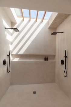 a bathroom with two shower heads and an open skylight