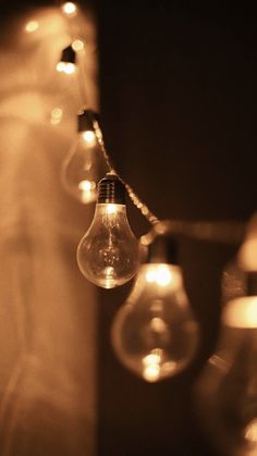 some light bulbs are hanging from a wall with lights on the sides and in between them