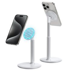 two cell phones are charging on the same stand as one is holding an iphone in its holder