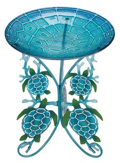 a blue glass table with flowers and leaves on the top, sitting in front of a white background