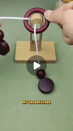 a person is playing with an object on the table and it looks like they are making something out of wood