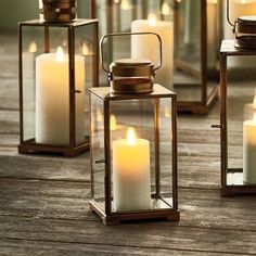 several lit candles sitting on top of a wooden table