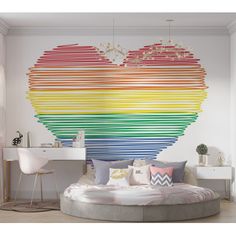 a bedroom with a large rainbow heart wall mural on the wall and a round bed in front of it