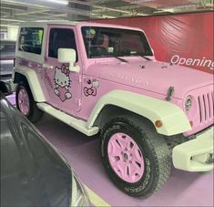 a pink jeep with hello kitty decals on it's side in a showroom