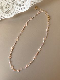 "This necklace features pearl, several shades of pink,and 24k gold plated seed beads. It also contains clear and pink crystal beads. Length: 15\" inches Seed Bead Size: 11/0, 6/0, 4mm Adjustable: Each necklace has a 2.5\" gold filled lobster clasp extender Strung on: Non-Stretchy Beading Thread" Feminine Gold Beaded Necklaces, Feminine Beaded Necklaces For Jewelry Making, Beaded Flower-shaped Pearl Necklace, Pink Pearl Chain Beaded Necklaces With Round Beads, Pink Pearl Chain Beaded Necklace With Round Beads, Pink Pearl Jewelry With Tiny Beads, Pink Pearl Chain Necklace With Round Beads, Rose Gold Beaded Pearl Necklaces, Dainty Pink Beaded Necklace With Tiny Beads