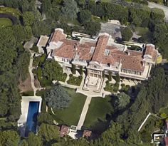 an aerial view of a large house surrounded by trees