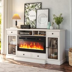 a white entertainment center with a fire in the fireplace