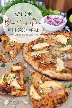 bacon blue cheese pizza with green apple toppings on a wooden cutting board next to bowls of salad