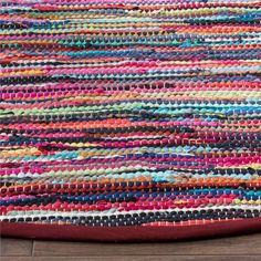 a multicolored rug on the floor with wooden floors and wood planks in the background