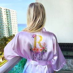 Experience the luxury of our kimono floral robe with a unique monogram design. This silk robe for women is not just a custom bathrobe, it's a statement of elegance and sophistication. Perfect as a bridal robe for the bride, it adds a touch of glamour to your special day. Our women's bathrobe is made from the finest satin, ensuring a comfortable fit and a luxurious feel. The bride robe is adorned with a beautiful floral pattern, making it a stunning floral robe. Personalize your robe with our per Summer Wedding Satin Robe, Spring Wedding Satin Sleepwear, Wedding Robe With Kimono Sleeves For Spring, Spring Wedding Robe With Kimono Sleeves, Spring Wedding Sleepwear With Kimono Sleeves, Satin Robe For Wedding Night In Summer, Summer Wedding Night Satin Robe, Feminine Satin Robe For Summer, Feminine Satin Summer Robe