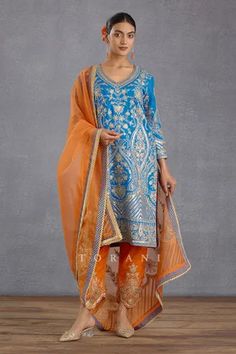 Persian blue straight kurta with all-over gota patti embroidery. Comes with orange pant and sheer dupatta.
Components: 3
Pattern: Embroidery and Print
Type Of Work: Hand Adda Work, Gota and Digital Bhagalpuri Print
Neckline: V neck
Sleeve Type: Full
Fabric: Kurta and Pant: Slub Silk and Dupatta: Silk Organza
Color: Blue,Orange
Other Details: 
Dupatta with scallop lace border
Kurta with side slits
Pant with scallop hem
Occasion: Wedding - Aza Fashions Embroidery Samples, Sheer Dupatta, Traditional Suit, Persian Blue, Scallop Hem, Embroidery Suits Design, Indian Textiles, Boutique Dress Designs, Straight Kurta