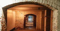 an alley way with brick walls and arched doorways