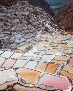 the ground is covered with colored rocks and dirt, while mountains are in the distance