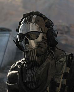 a man with sunglasses and a skull face paint job in front of a mountain range