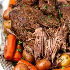 a white plate topped with roast, potatoes and carrots