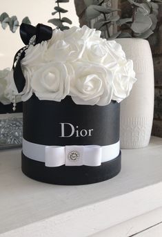 a black and white hat with flowers on it is sitting on a table next to a mirror