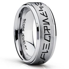 a men's wedding ring with an inscription on the side and black lettering in white gold