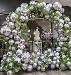 a mirror with silver balls and greenery on it