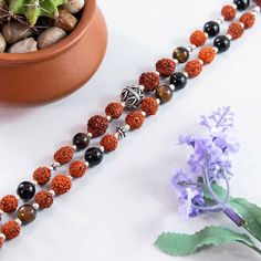 Just like physical core strength, our spiritual core strength is of vital importance for our growth and well being. The Core Strength mala is designed to guide you towards developing a strong spiritual center and provides the strength, endurance and guidance that enables you to face life's toughest challenges with calmness. This is a powerfully strong 108 beads mala featuring Rudraksha paired with Black Onyx, Tiger Eye and Sterling Silver mantra beads. Core Strength will prove to be the cornerst Spiritual Gemstone Beaded Bracelets For Meditation, Holistic Healing Beads For Festivals, Spiritual Polished Beads For Meditation, Spiritual Mala With Polished Beads For Healing, Spiritual Healing Mala With Polished Beads, Spiritual Center, Rudraksha Beads, Beads Mala, 108 Mala Beads