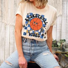 Show your love of the game with this retro style basketball vibes super soft t-shirt. This is a fun distressed retro basketball school spirit shirt for the games and everyday wear! It Makes the perfect basketball mom shirt! This vintage tee is everything you've dreamed of and more. This vintage shirt is perfect for the season layered under your favorite cardigan! It feels soft and lightweight, with the right amount of stretch. It's comfortable and flattering for all.  Show off your personality with our fun and unique designs!   ** P R O D U C T   D E T A I L S **  - High Quality, Super Soft and Comfy Bella + Canvas T-Shirt  - 100 % Pre-Shrunk Cotton  (heather colors are polycotton blend)  - Direct to Garment print (no stencils or vinyl which means it will last a lot longer)   - Printed and Retro School Shirts, Basketball Game Day Shirts, Casual Basketball T-shirt With Screen Print, Throwback Relaxed Fit Tops For Game Day, Relaxed Fit Throwback Tops For Game Day, Basketball Fan Apparel Cotton T-shirt, Casual Basketball T-shirt With Letter Print, Throwback Graphic Print Top For Game Day, Cotton Crew Neck T-shirt For Basketball