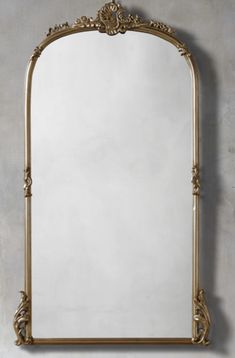 an ornate gold framed mirror against a wall