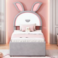 a child's bedroom decorated in pink and grey with a bunny head on the wall