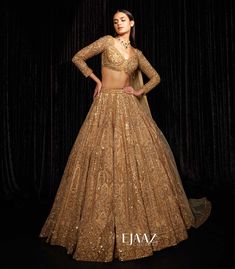 a woman in a gold lehenga and crop top with sequins on it