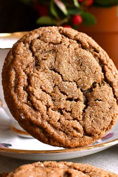 two cookies sitting on top of a white plate next to a cup and saucer