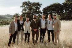 a group of men standing next to each other in a field