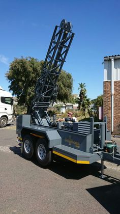 a truck with a crane attached to it's back parked in a parking lot