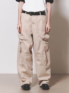 This is a comfortable cargo pants that is made out of sturdy cotton 100% fabric. With a unique cut pattern and wide adjustable silhouette with snaps on the hem, you can wear it for casual and daily outfit. - YKK zipper closure- Adjustable YKK snaps on the hem- Leather logo label detail- Wide silhouette Beige Utility Pants With Patch Pockets, Beige Utility Pants With Flap Pockets, Beige Cotton Utility Cargo Jeans, Beige Cotton Cargo Jeans With Pockets, Beige Baggy Cargo Jeans For Streetwear, Beige Cotton Cargo Jeans, Beige Utility Cargo Pants With Pockets, Beige Utility Bottoms With Cargo Pockets, Utility Style Beige Bottoms With Cargo Pockets