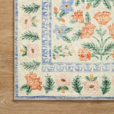 a white rug with flowers and leaves on it