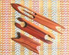 three pieces of wood sitting on top of a woven tablecloth covered in checkered fabric