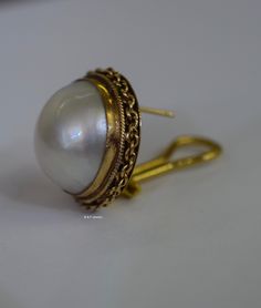 Metal: 14kt Yellow Gold Stone: Mabe Pearl Shape: Round Approximate Demensions Mabe Pearl: 17.50mm Type Of Backing: Post Omega Clip Back Weight of entire piece with stones: 15.90grams Diameter of Earrings: 21.39mm Age: Vintage. Approximately 1960's. Note: If you need this for non-pierced earrings we can remove the posts to make them clip ons. Please state in note to seller box at checkout if needed. Amethyst And Diamond Ring, Mabe Pearl, Filigree Design, Gold Stone, Gold Dipped, Ruby Diamond, Matching Band, Pierced Earrings, Earrings Photo