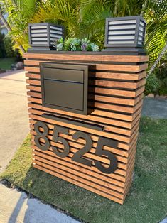 a mailbox with plants growing out of it's top and numbers on the side