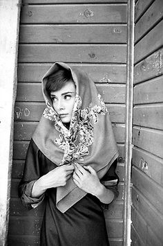 black and white photograph of woman wearing a shawl over her head with flowers on it