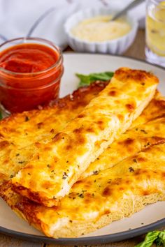 two cheesy bread sticks on a plate with ketchup