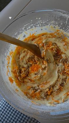 a bowl filled with food sitting on top of a counter next to a wooden spoon