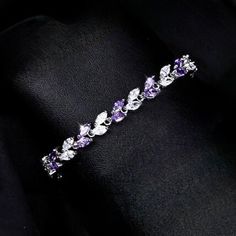 Romantic. Classy. Delicate. Rhodium plated for a flawless finish which perfectly enhances the intricate detailing, this exquisite bracelet will add a touch of sophistication to any wedding gown or formal ensemble. Each link is adorned with flawlessly faceted purple and clear cubic zirconia that capture the light from every angle with a perfectly translucent appeal, sparkling beautifully. Available in two lengths: 6.5" (approx. 16.5cm) and 7.75" (approx. 19.6cm). To make your choice select your p Elegant Wedding Chain Bracelet, Elegant Cubic Zirconia Bangle For Gifts, Elegant Anniversary Bangle With Sparkling Stones, Wedding Cubic Zirconia Diamond Bracelet In White Gold, Elegant Cubic Zirconia Bangle For Party, White Gold Charm Bracelet For Wedding, Elegant Silver Crystal Bracelets, Dainty White Gold Chain Bracelet For Wedding, Elegant Formal Cubic Zirconia Chain Bracelet