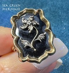 Welcome to Sea Green Mermaid! For sale is a 10k yellow gold onyx signet ring with a diamond forget-me-not. This Victorian era mourning ring has wonderful gothic styling. I had my jeweler make this ring from a brooch so it would be worn and enjoyed. The ring has a large rectangular 10k gold frame with elegantly scalloped edges. The onyx is decorated with a silver forget-me-not flower set with tiny rose-cut diamonds. The flower is lovely, with a curving stem and a pin-wheel style flower. Each leaf Pin Wheel, Onyx Signet Ring, Jelly Opal, Forget Me Not Flower, Green Mermaid, Scalloped Edges, Opal Earrings, Emerald Cut Diamonds, Forget Me Not